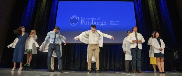 Five new medical students get their white coats.